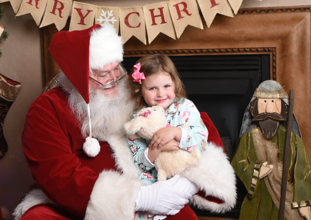 Santa poses for photo shoot with small girl