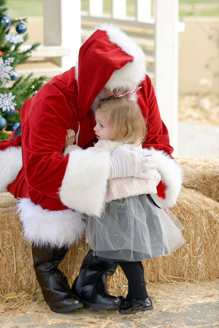 Small girl gives Santa Claus a hug