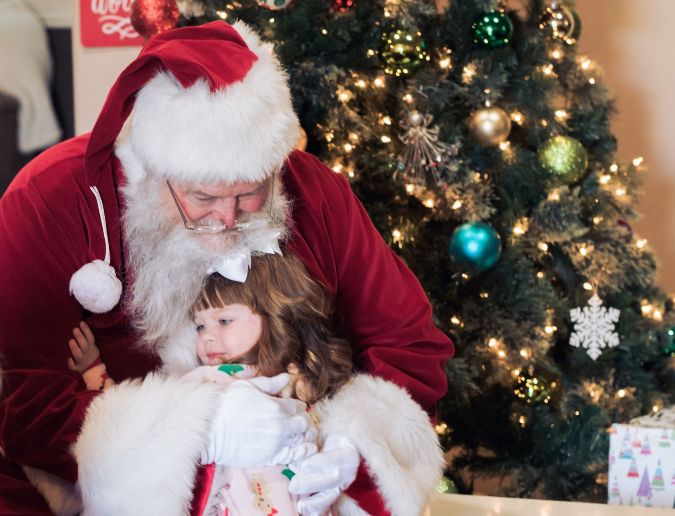 Santa gets a hug from a young girl